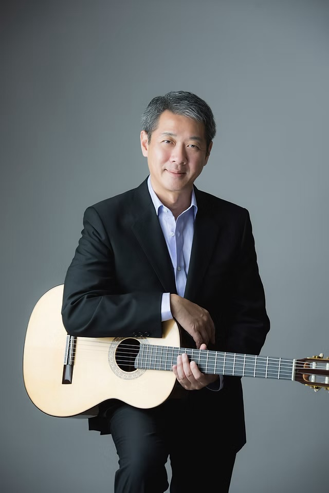 Portrait of Patrick Lui holding a classical guitar